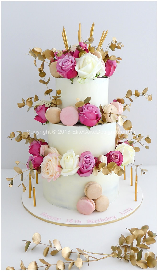 Thin gold candles on the cake and cake board